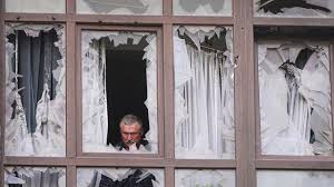 A man stands at the broken windows of his house after a Russian attack in Kyiv, Ukraine, Monday, July 21, 2025. (AP Photo/Efrem Lukatsky)
