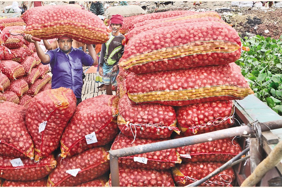 Labourers unloading sacks of onion on Friday from a mechanised boat that carried the commodity to Shyambazar, a wholesale market in the capital, through the Buriganga. Onion prices skyrocketed in the last two weeks, rising by Tk 20-30 per kg. — FE photo