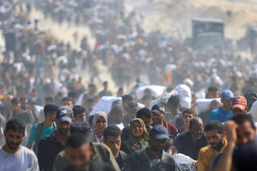 Palestinians carry aid supplies they collected from trucks that entered Gaza through Israel, in Beit Lahia, in the northern Gaza Strip August 10, 2025.