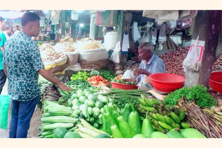 A customer bargains with a seller at a vegetable shop at Rangpur City Bazar in Rangpur town