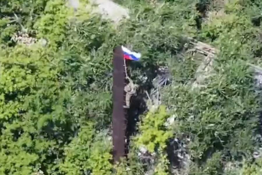 A still image, taken from footage released by the Russian Defence Ministry, shows what it said to be a Russian soldier raising a flag following the capture of Ukraine's Yablunivka (Yablonovka) settlement in the Donetsk region in the course of Russia-Ukraine military conflict, in this image from video released August 12, 2025.
