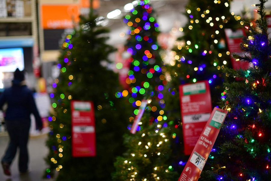 A shopper walks past artificial Christmas trees for sale at a Home Depot store in Wilmington, Delaware US November 19, 2020.
