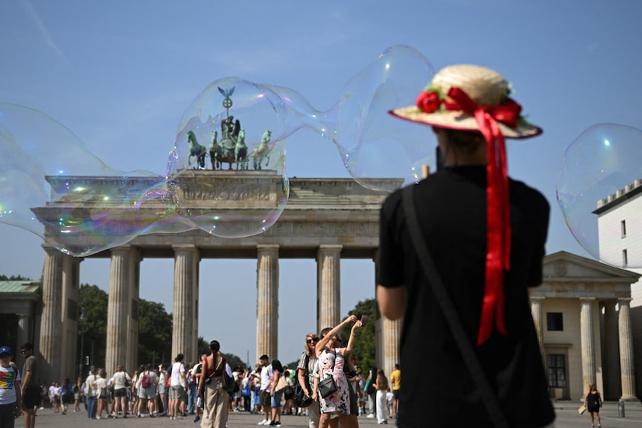 A woman takes a photo of the Brandenburg Gate with her mobile phone in Berlin, Germany, August 15, 2025.