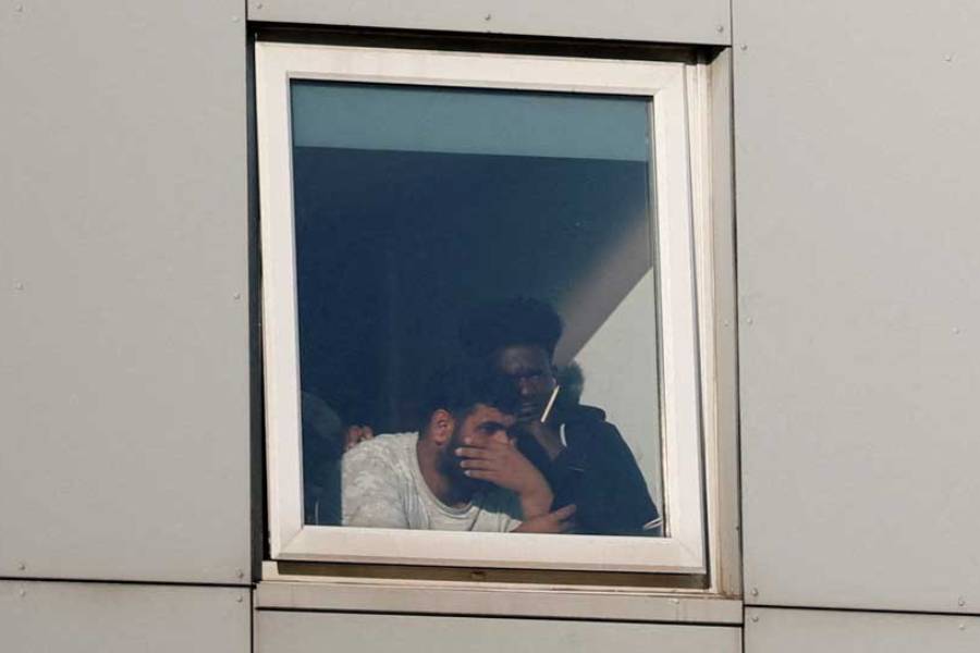 Asylum seekers react as they look out the window at the Cresta Court hotel, as people take part in an anti-immigration demonstration outside the hotel, in Altrincham, Britain, August 8, 2025.