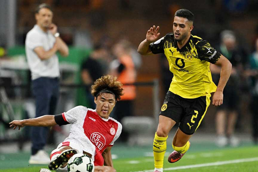 Rot-Weiss Essen’s Kaito Mizuta in action with Borussia Dortmund’s Yan Couto - DFB Cup - First Round - Rot-Weiss Essen v Borussia Dortmund - Stadion Essen, Essen, Germany - Aug 18, 2025.