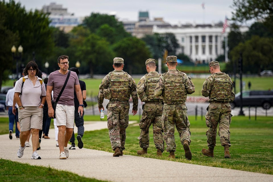 Members of the National Guard walk near the White House on the National Mall after US President Donald Trump deployed the National Guard and ordered an increased presence of federal law enforcement to assist in crime prevention, in Washington, DC, US, August 21, 2025.