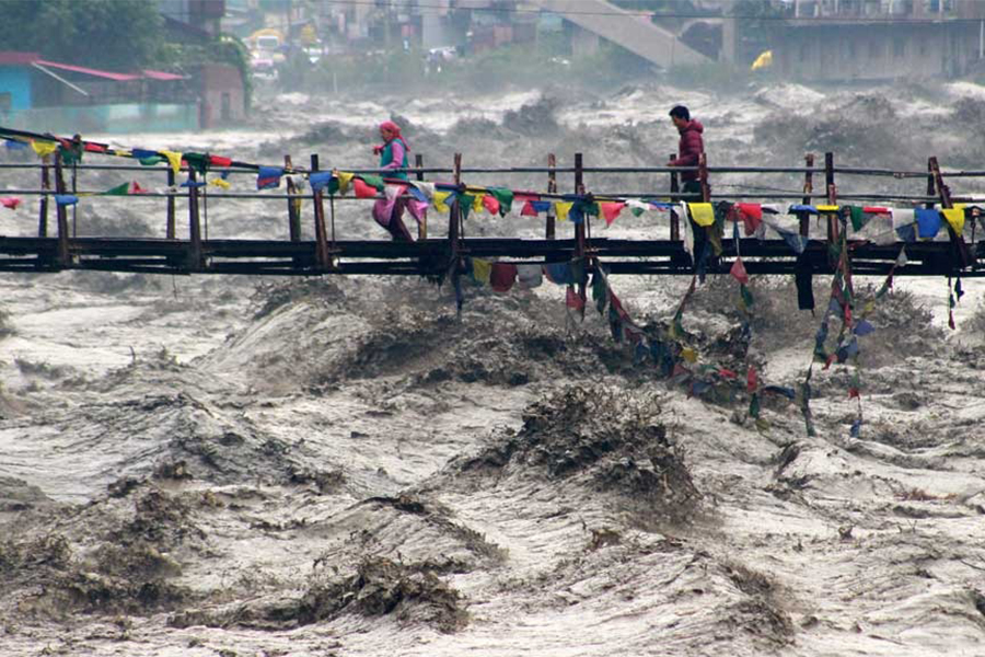 People walk on a bridge to cross the overflowing river Beas following heavy rain in Kullu district in the northern state of Himachal Pradesh, India on August 26, 2025 — Reuters photo