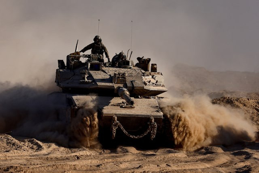 An Israeli tank manouvres at the Israel-Gaza border, as seen from Israel, August 26, 2025.