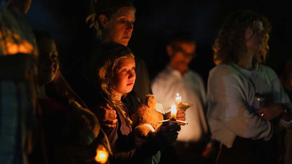 A tear falls down Linnea Opsahl’s cheek as she joins her mother Laura during a vigil at Lynnhurst Park following a shooting earlier in the day at Annunciation Church in Minneapolis, Minnesota, US August 27, 2025. REUTERS