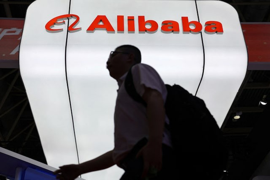 A man walks past the Alibaba logo displayed at its booth during the China International Supply Chain Expo in Beijing, China July 16, 2025.