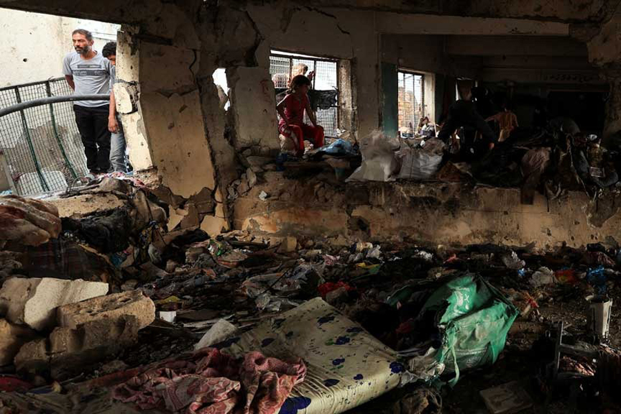 Palestinians inspect the site of an overnight Israeli air strike on a school that was sheltering displaced people, in Gaza City, September 7, 2025.