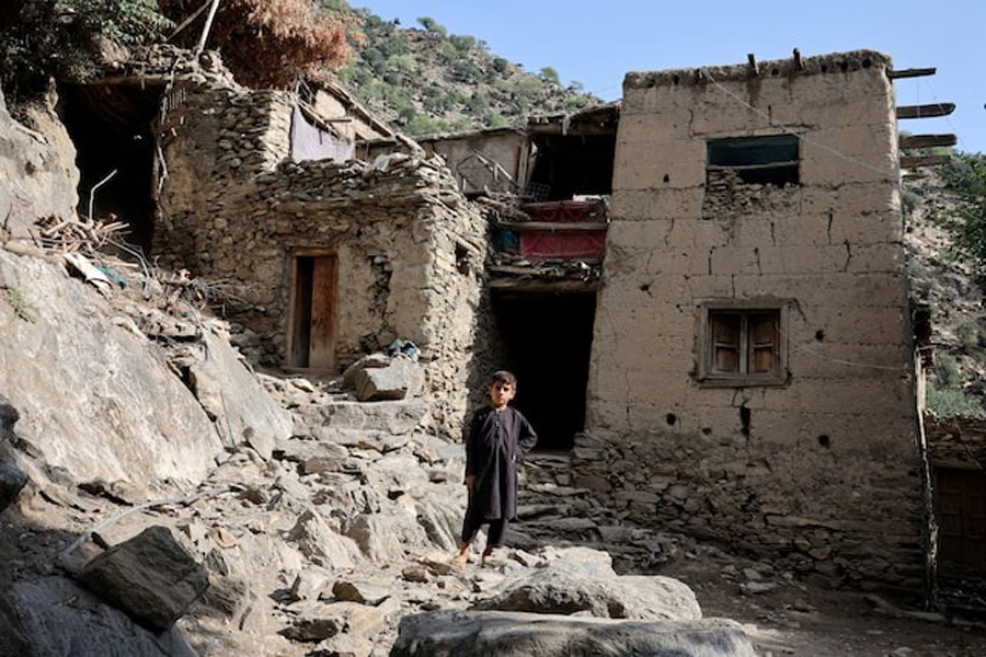 A boy stands in front of houses damaged by a deadly earthquake that struck Afghanistan's Kunar and Nangarhar provinces, at Masud village in Nurgal district, Kunar province, Afghanistan, September 4, 2025.