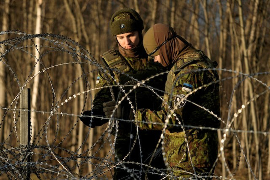 Estonian army reservists build a temporary razor wire fence on a border with Russia during a snap military exercise Okas 2021 near Meremae, Estonia November 20, 2021.