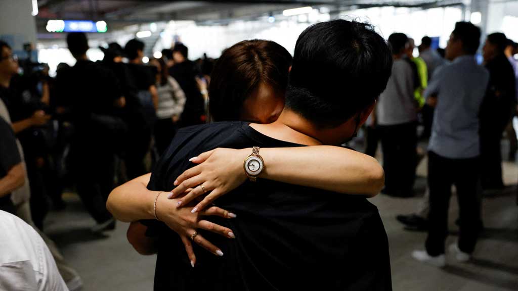 A South Korean worker who was detained in a huge immigration raid last week at the site of a US car battery project involving Hyundai Motor and LG Energy Solution in the US state of Georgia, hugs a family member in the long term parking lot at the Incheon International Airport in Incheon, South Korea, Sept 12, 2025. REUTERS