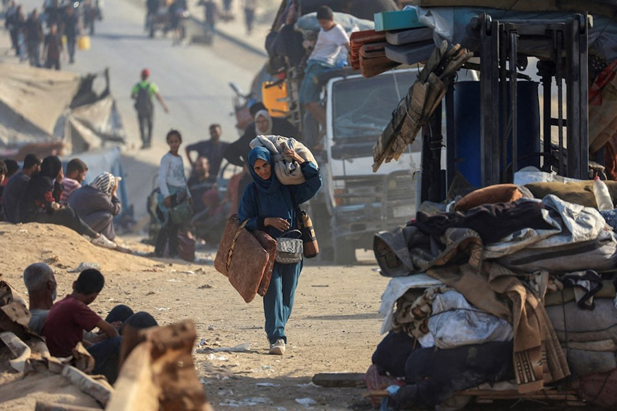 A displaced Palestinian woman, fleeing northern Gaza due to an Israeli military operation, walks with he belongings as she moves southward after Israeli forces ordered residents of Gaza City to evacuate to the south, in the central Gaza Strip on September 22, 2025 — Reuters photo