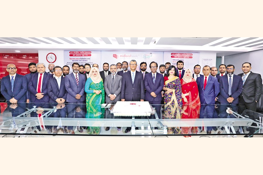 Managing Director & CEO of Midland Bank Md Ahsan-uz Zaman along with other high officials pose at the cake-cutting ceremony marking the 10th anniversary of the bank at its head office in Dhaka on Tuesday.