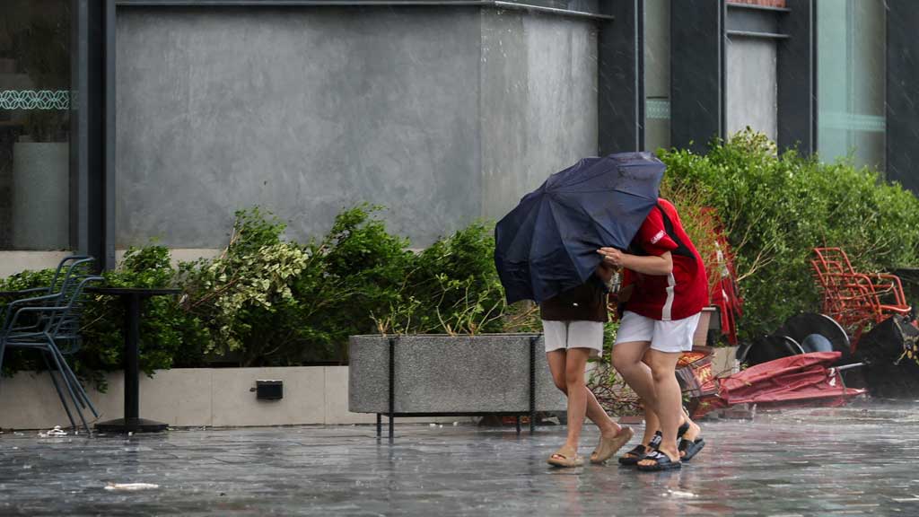 People use an umbrella to protect themselves from a strong wind after Typhoon Bualoi makes landfall in Nghe An province, Vietnam, September 29, 2025. REUTERS
