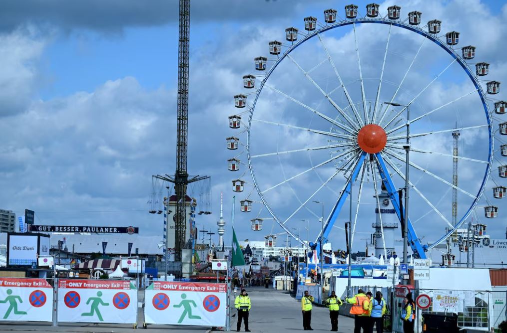 Security stands in front of an Theresienwiese entrance as the Oktoberfest beer festival will remain shut until at least 5 pm (1500 GMT) today, after police said they discovered explosives in a residential building in the north of the city that caught fire and left one person dead in Munich, Germany, October 1, 2025. REUTERS/Fariha Farooqui