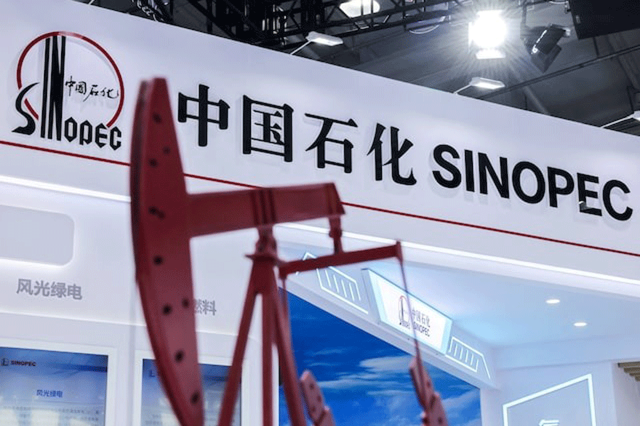 A model of oil pump jack stands next to a logo of China Petroleum & Chemical Corporation, or Sinopec, at the company's booth at the China International Fair for Trade in Services (CIFTIS) in Beijing, China, September 11, 2025.