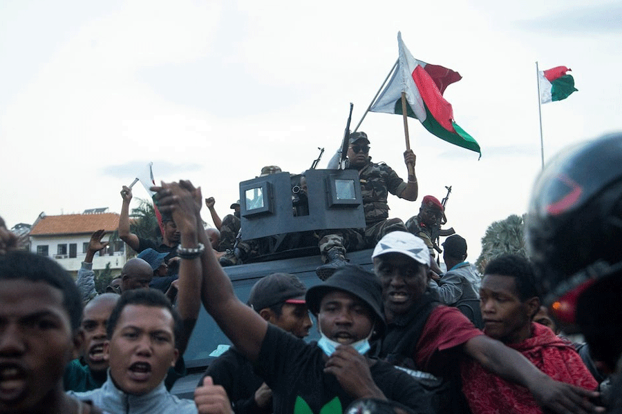 Protesters cheer next to a Madagascar military vehicle during a nationwide youth-led protest over frequent power outages and water shortages, in Antananarivo, Madagascar, October 11, 2025.