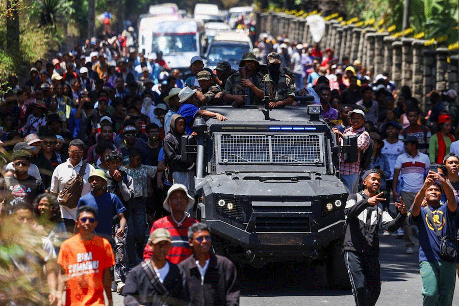 Protesters march alongside a Madagascar military vehicle during a nationwide youth-led protest over frequent power outages and water shortages, in Antananarivo, Madagascar, October 13, 2025.