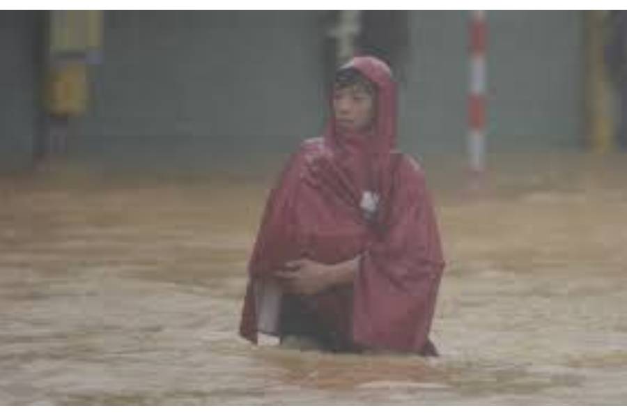 A man wades in a flooded street in Hue, Vietnam, Tuesday, Oct. 28, 2025.