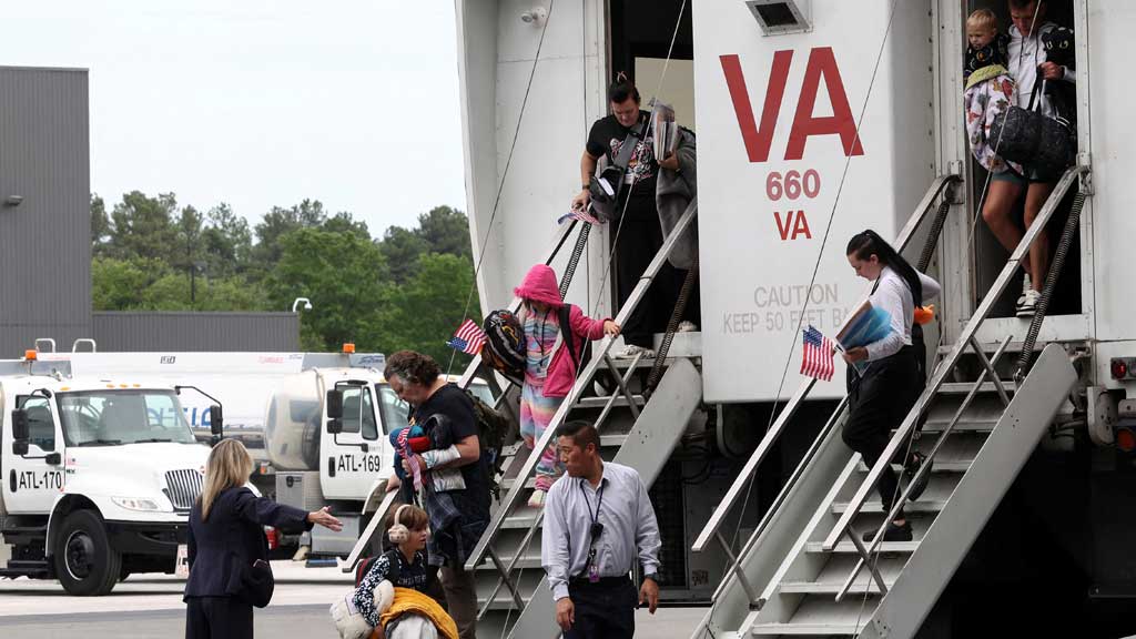 The first group of white South African refugees step from a "people mover" upon arrival at Dulles International Airport in Dulles, Virginia, US, May 12, 2025. REUTERS
