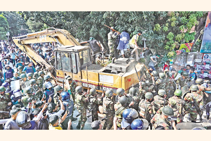 Military personnel and policemen baton-charge a demonstrating crowd as they brought an excavator to demolish the residence of Sheikh Mujibur Rahman on Dhanmondi 32 during the announcement of the verdict against deposed Prime Minister Sheikh Hasina on Monday. — FE Photo