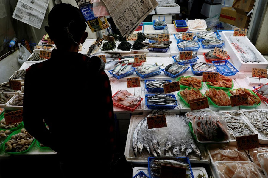 A customer looks around seafood at a shop in Tokyo, Japan November 19, 2025.