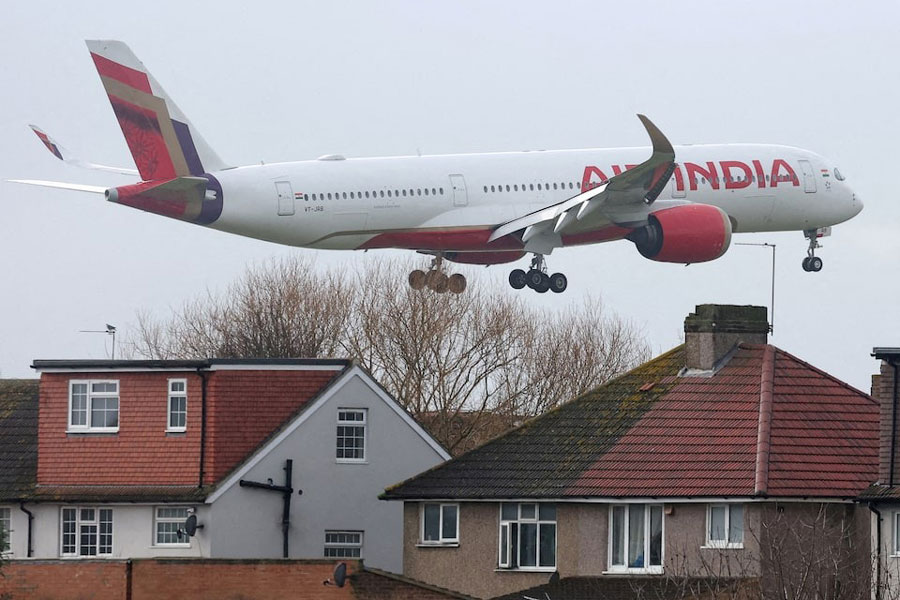An Air India passenger plane flies near houses as it makes its landing approach to Heathrow Airport in west London, Britain, January 28, 2025.