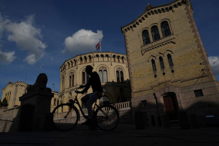 A cyclist bikes past Norway's parliament in Oslo, Norway, August 26, 2025.