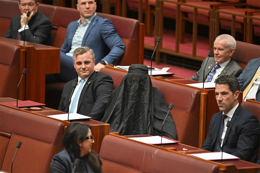 Senators react as One Nation leader Pauline Hanson wears a burqa in the Senate chamber at Parliament House in Canberra, Australia on November 24, 2025 — AAP via REUTERS