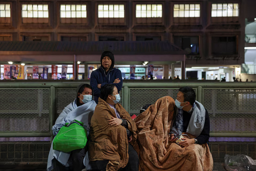 Evacuees wrapped in blankets rest on a nearby platform after a major fire at Wang Fuk Court housing estate, in Tai Po, Hong Kong, China on November 26 — Reuters photo
