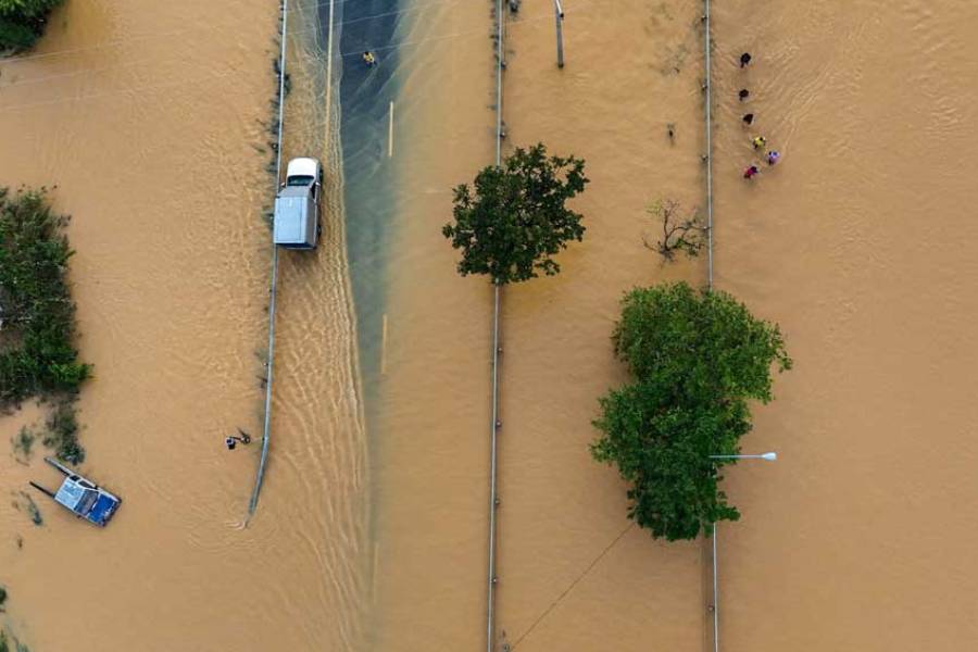 A drone view shows people wading through a flooded area in Hat Yai district, affected by deadly flooding following heavy rainfall in southern Thailand, in Songkhla province, Thailand, Nov 27, 2025.