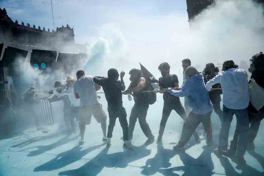 Demonstrators try to pull down a barrier during a protest against insecurity and corruption in the country, outside the National Palace, in Mexico City, Mexico, November 15, 2025.