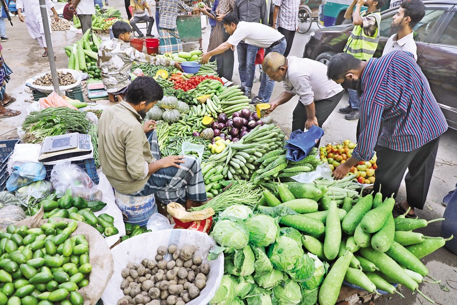 Consumers buy winter vegetables from street vendors in the capital's Motijheel on Friday. Prices are high despite ample supply, with sellers blaming October rains that damaged vegetable fields — FE photo