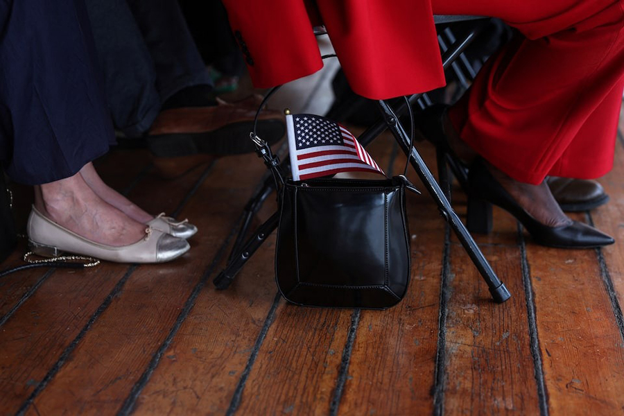 A US flag sticks out from the purse of a citizen candidate attending a US Citizenship and Immigration Services (USCIS) naturalisation ceremony aboard the 1885 Tall Ship Wavertree at the South Street Seaport in New York City, US on June 14, 2023 — Reuters/File