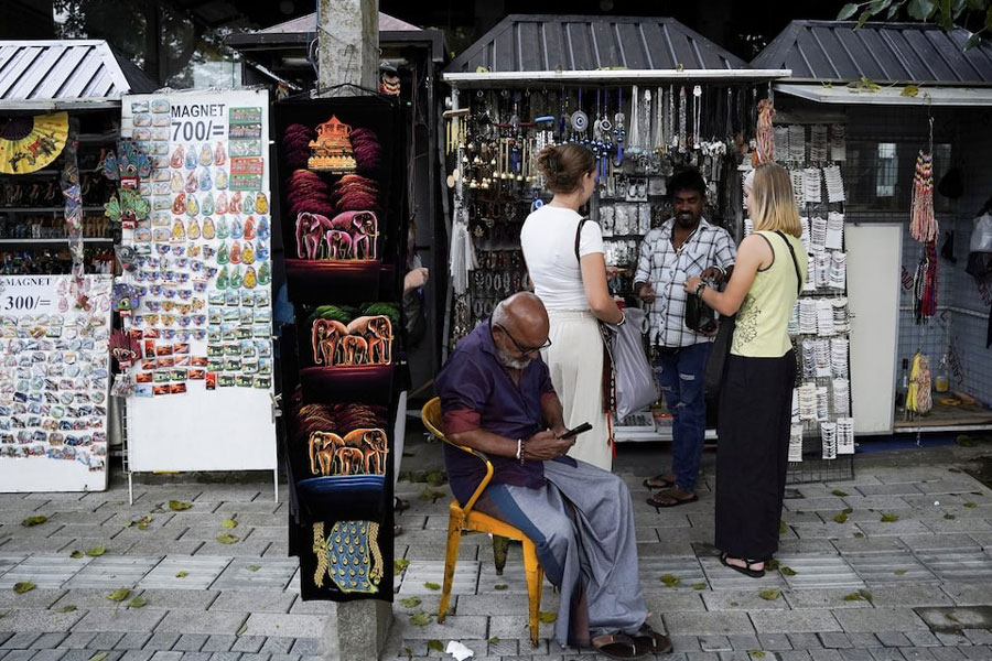 Tourists buy souvenirs from a roadside stall near the Temple of the Tooth, also known as Sri Dalada Maligawa, following Cyclone Ditwah, in Kandy, Sri Lanka, December 4, 2025.