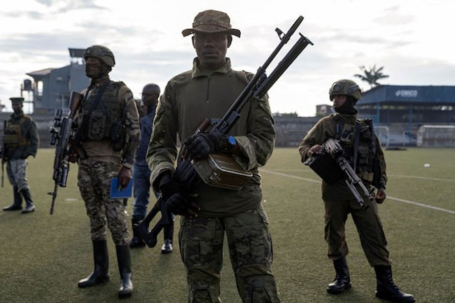 M23 rebels stand guard at the the Unite stadium, where captured members of the armed forces of the Democratic Republic of the Congo (FARDC) and Wazalendo troops wait to be taken aboard trucks for training by M23 rebels, in Goma, North Kivu, Democratic Republic of Congo, May 10, 2025.