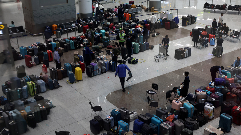 Staff members of IndiGo tag stranded bags and belongings of IndiGo passengers following large-scale flight disruptions, at Terminal 1 of Indira Gandhi International Airport in New Delhi, India, Dec 8, 2025. REUTERS