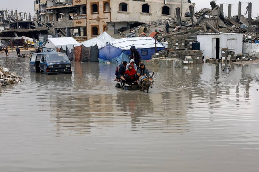 Displaced Palestinians ride a donkey-drawn cart on a rain-flooded street in Gaza City, Dec 12, 2025.