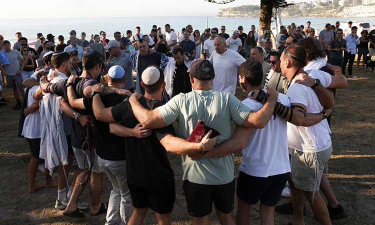 Members of the Jewish community gather for Shacharit, morning prayers, as the crime scene was reopened following the mass shooting at Bondi Beach on Sunday, in Sydney, Australia, Dec 19, 2025. REUTERS/Hollie Adams