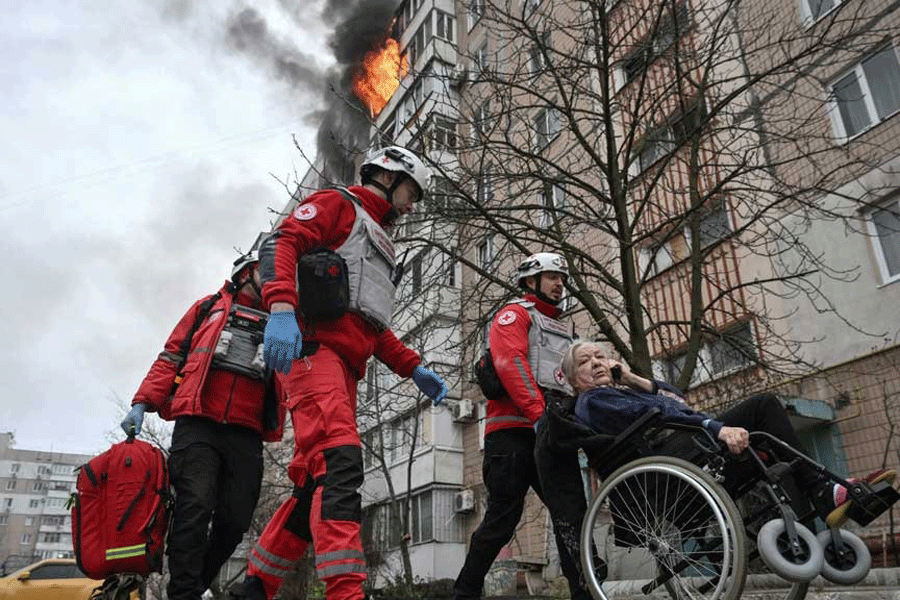 Paramedics assist a resident during an evacuation from an apartment building hit by a Russian air strike, amid Russia's attack on Ukraine, in Zaporizhzhia, Ukraine Dec 17, 2025.