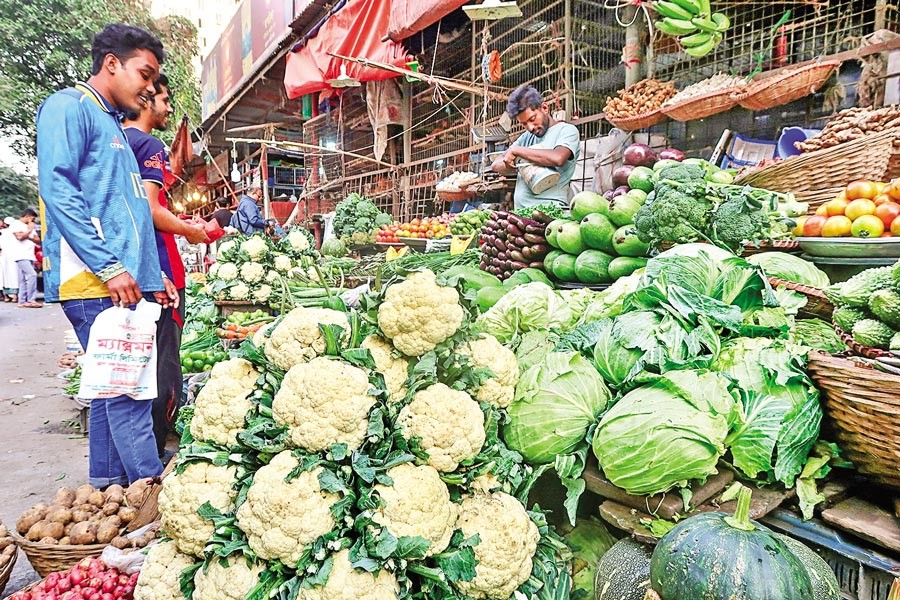 Buyers making their choice of winter vegetables at Hatirpul Kitchen Market in the capital on Friday. — FE Photo