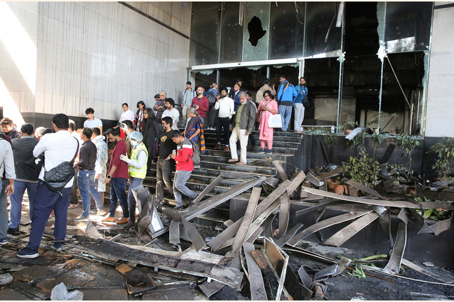 Journalists and staffers in front of burnt building of The Daily Star in Dhaka —FE Photo