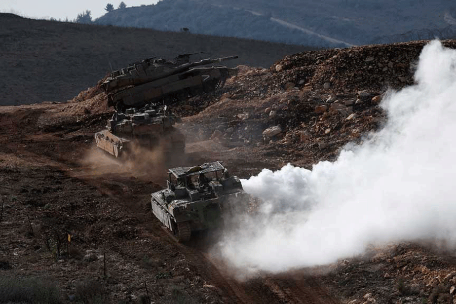 Israeli military vehicles manoeuvre along the Israel-Lebanon border, as seen from northern Israel, November 24, 2025.