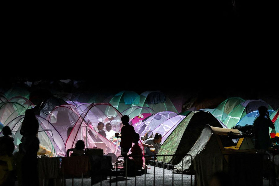 Displaced people gather inside a temporary shelter amid clashes between Thailand and Cambodia along a disputed border area, in Buriram province, Thailand, December 16, 2025.