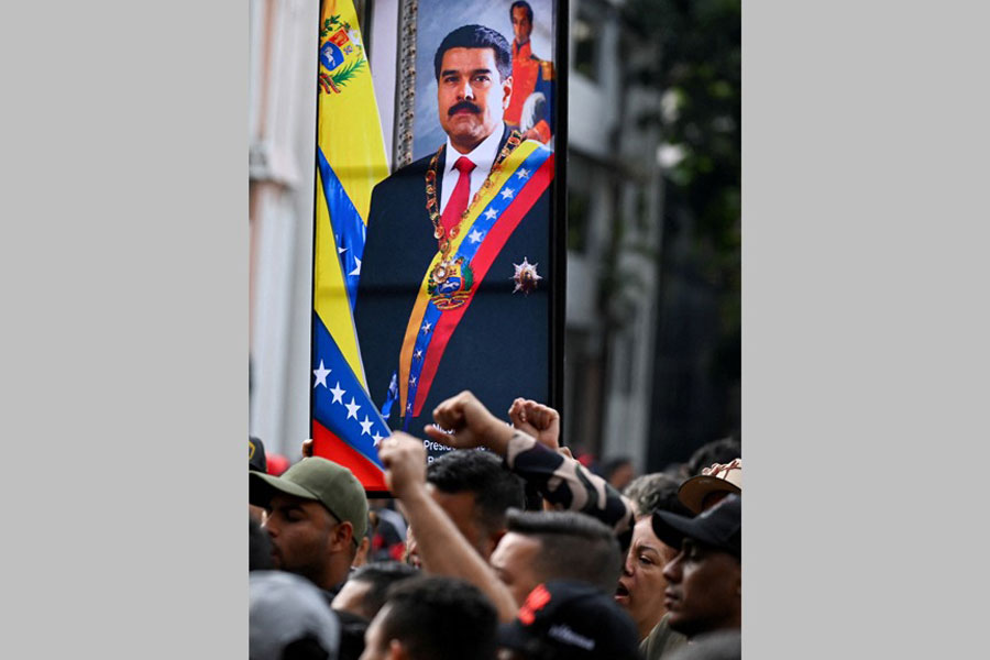 Government supporters gesture near a photograph of Venezuela's President Nicolas Maduro, after US President Donald Trump said the US has struck Venezuela and captured Maduro, in Caracas, Venezuela Jan 3, 2026.