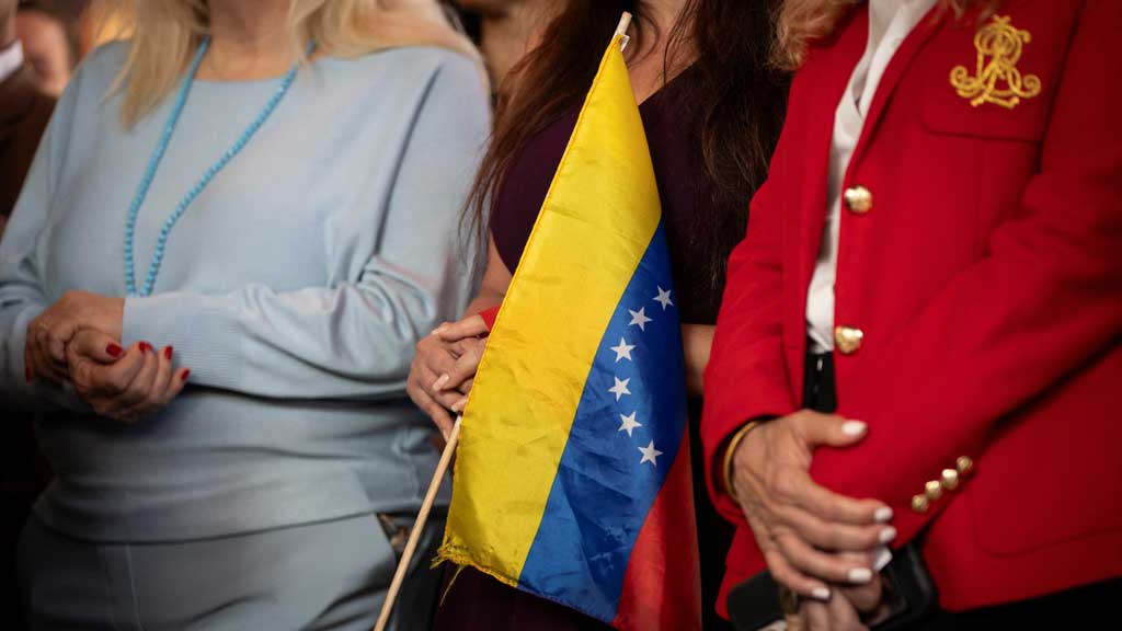 A woman holds a Venezuelan flag during a press conference on the US strikes in Venezuela, in Doral, Miami-Dade County, Florida, US, Jan 5, 2026. REUTERS