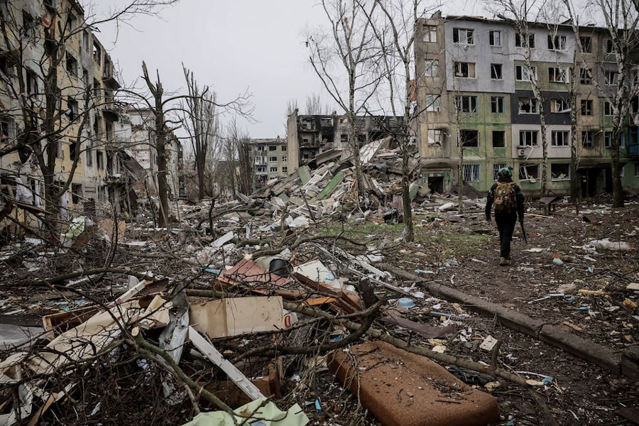 Ukrainian serviceman walks near apartment buildings damaged by Russian military strike, amid Russia's attack on Ukraine, in the frontline town of Kostiantynivka in Donetsk region, Ukraine December 20, 2025.
